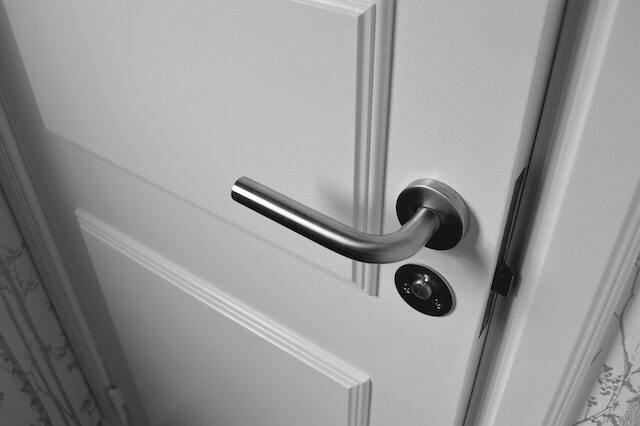 white ajar door with a metal doorknob